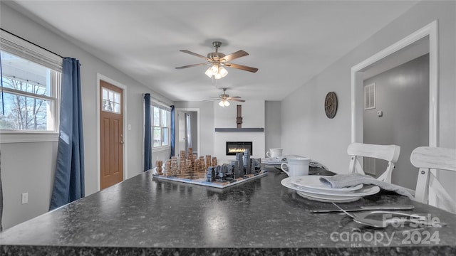 interior space featuring ceiling fan and a large fireplace