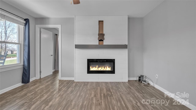 unfurnished living room with hardwood / wood-style floors and ceiling fan