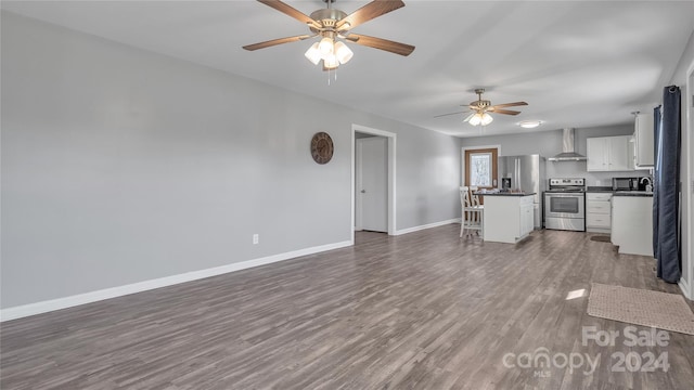 unfurnished living room featuring dark hardwood / wood-style floors and ceiling fan