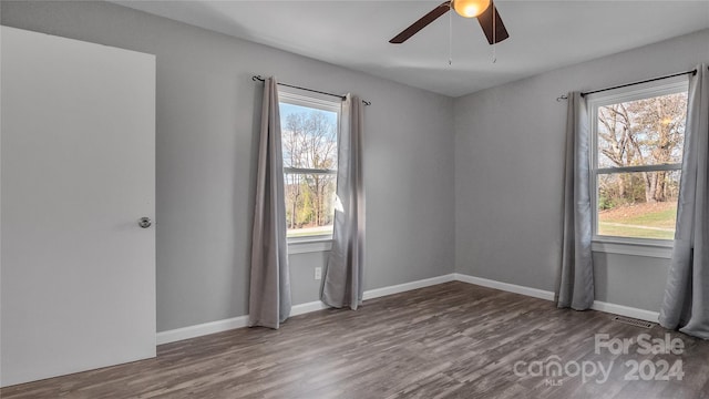 empty room with hardwood / wood-style flooring, ceiling fan, and a healthy amount of sunlight