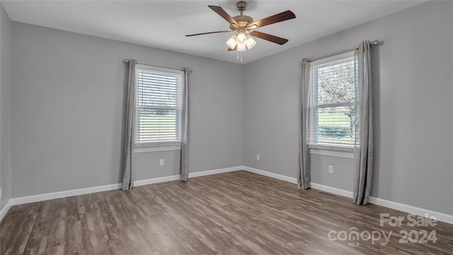 unfurnished room with hardwood / wood-style floors, ceiling fan, and a healthy amount of sunlight