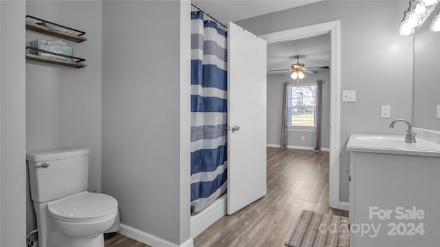 bathroom featuring walk in shower, vanity, ceiling fan, hardwood / wood-style floors, and toilet