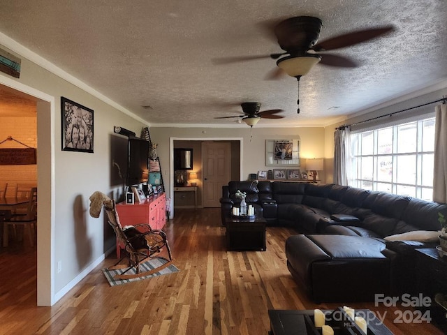 living room featuring ceiling fan, hardwood / wood-style floors, a textured ceiling, and ornamental molding