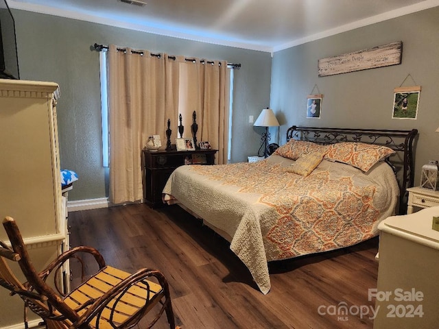 bedroom with dark hardwood / wood-style flooring and ornamental molding