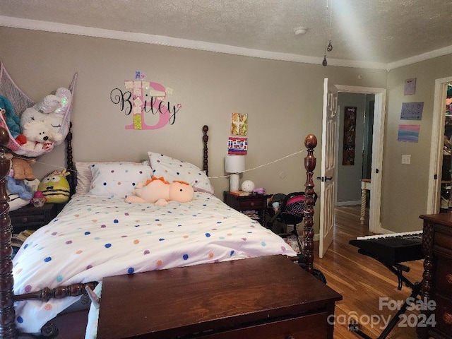 bedroom with ornamental molding, a textured ceiling, and dark wood-type flooring