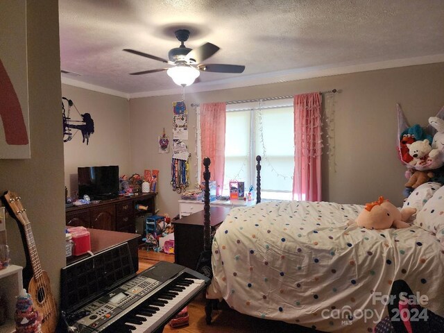 bedroom featuring ceiling fan, a textured ceiling, and ornamental molding