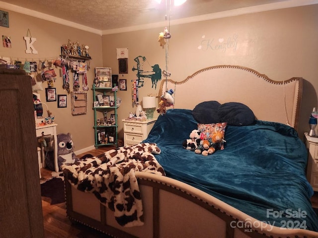 bedroom with dark hardwood / wood-style floors and a textured ceiling