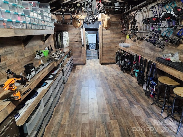 wine room with hardwood / wood-style flooring and wood walls