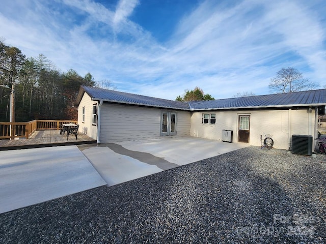 back of property featuring french doors, a patio, central AC, and a wooden deck