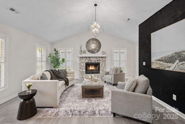 living room with vaulted ceiling, a wealth of natural light, and light wood-type flooring