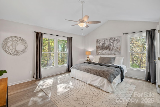 bedroom featuring ceiling fan, multiple windows, and light wood-type flooring