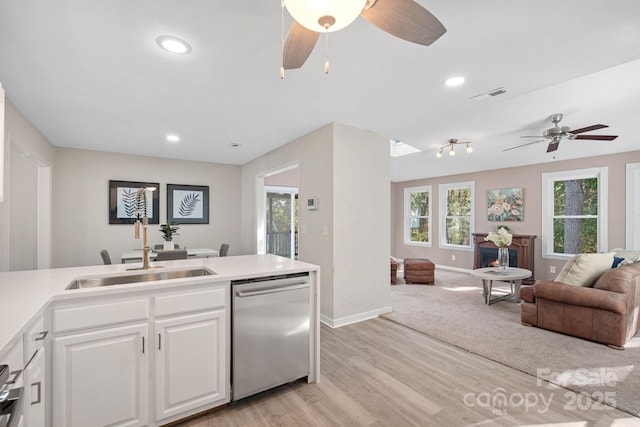 kitchen featuring white cabinetry, dishwasher, sink, ceiling fan, and light wood-type flooring