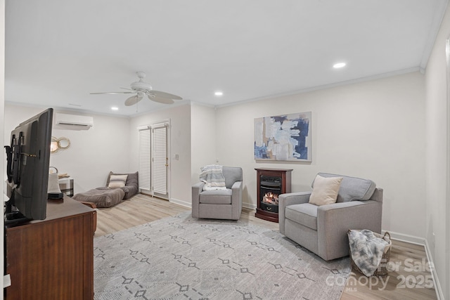 living area with ceiling fan, ornamental molding, light hardwood / wood-style floors, and a wall unit AC