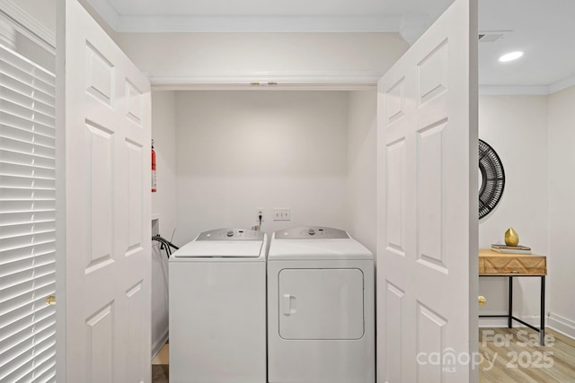 washroom featuring washing machine and dryer and crown molding