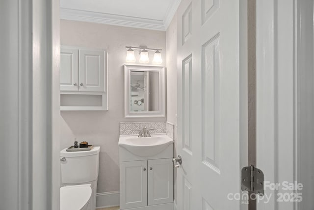 bathroom with crown molding, vanity, backsplash, and toilet