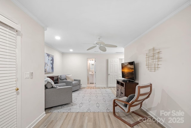 living room featuring ceiling fan, ornamental molding, and light hardwood / wood-style floors