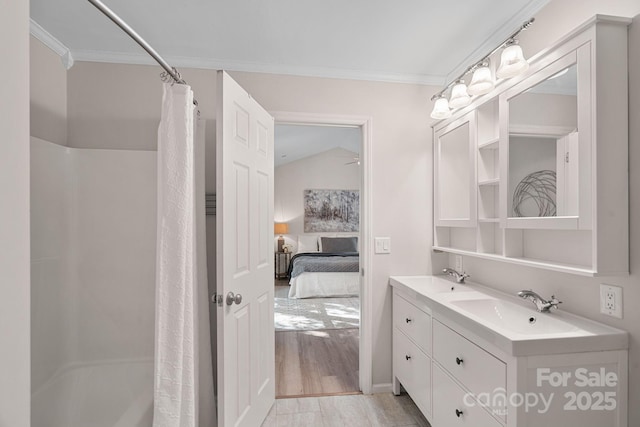 bathroom featuring lofted ceiling, crown molding, hardwood / wood-style flooring, vanity, and shower / bath combo