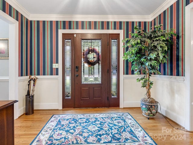 entryway with crown molding and hardwood / wood-style flooring