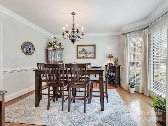 dining space with ornamental molding, light hardwood / wood-style flooring, and a chandelier