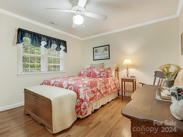 bedroom featuring hardwood / wood-style floors, crown molding, and ceiling fan