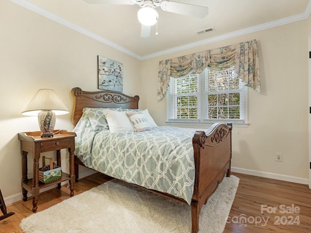 bedroom featuring ceiling fan, hardwood / wood-style flooring, and crown molding