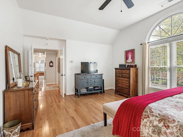 bedroom featuring lofted ceiling, light hardwood / wood-style flooring, multiple windows, and ceiling fan