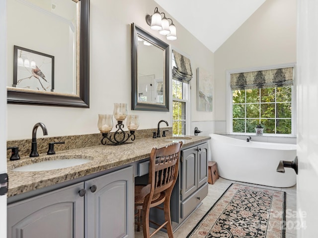 bathroom with vanity, vaulted ceiling, and a bathing tub