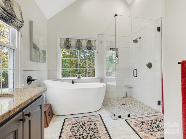 bathroom with plus walk in shower, tile walls, lofted ceiling, vanity, and tile patterned flooring