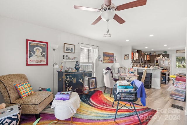 living room with ceiling fan, light wood-type flooring, and plenty of natural light