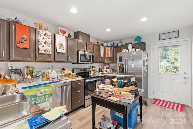 kitchen featuring appliances with stainless steel finishes, light hardwood / wood-style flooring, sink, and dark brown cabinets