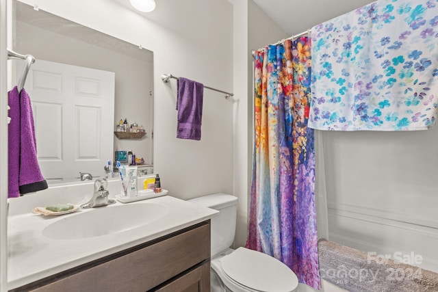 bathroom with toilet, curtained shower, and vanity