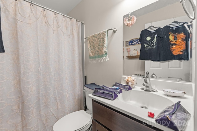 bathroom with vanity, toilet, and curtained shower