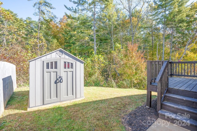 view of yard with a wooden deck and a storage unit