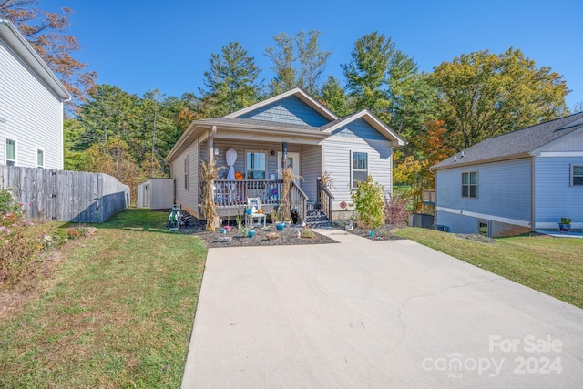 bungalow with central AC, a front yard, and a porch