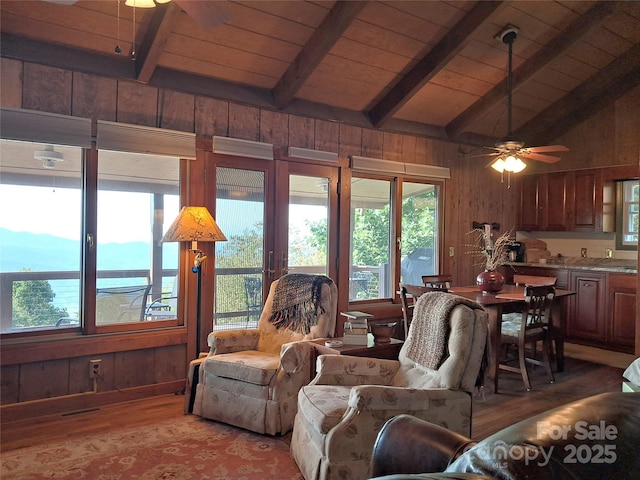 living room featuring wooden ceiling, vaulted ceiling with beams, and wooden walls