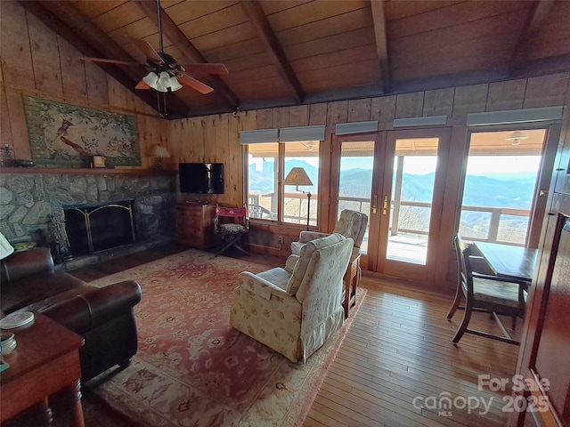 living room featuring a healthy amount of sunlight, wood ceiling, hardwood / wood-style floors, and lofted ceiling with beams