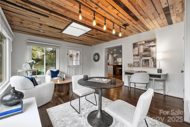 interior space featuring rail lighting, dark wood-type flooring, and wooden ceiling