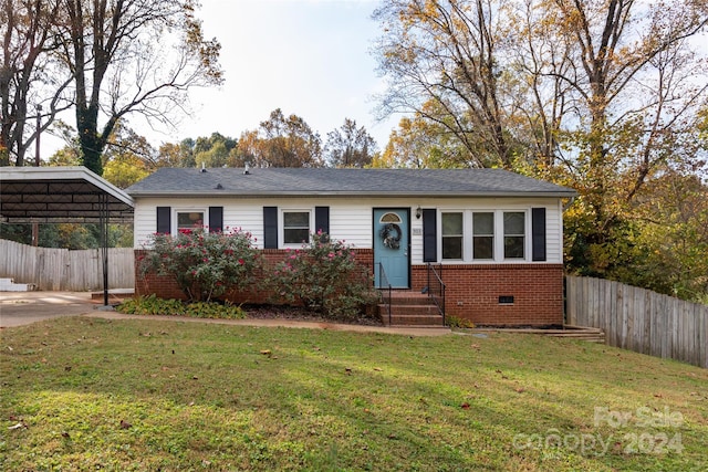ranch-style house featuring a front yard, a carport, brick siding, fence, and entry steps