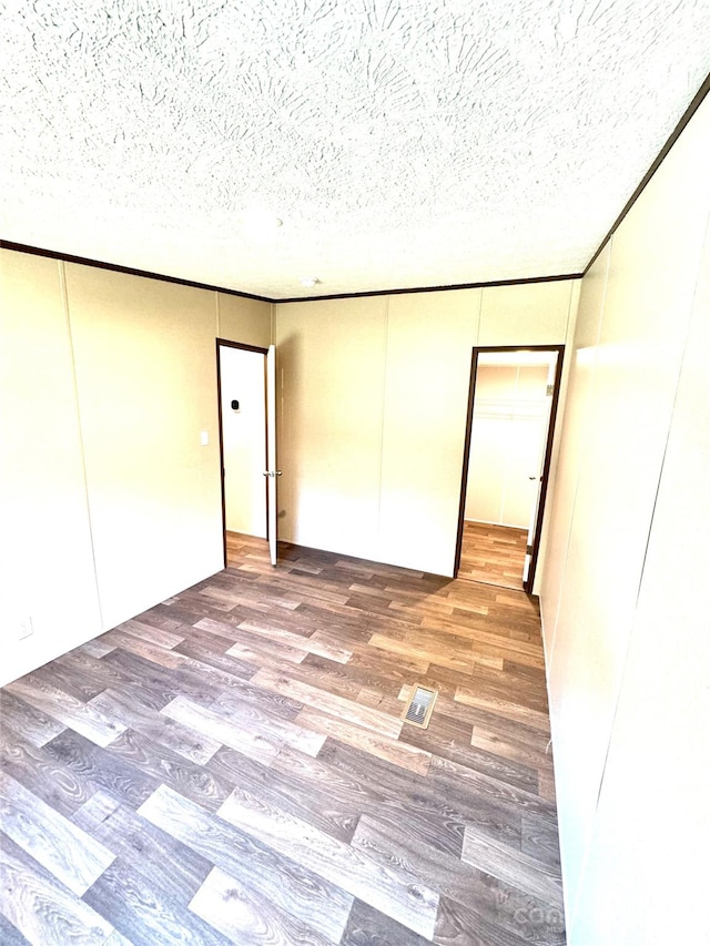 unfurnished room featuring hardwood / wood-style floors and a textured ceiling