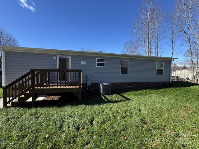 rear view of house featuring central air condition unit, a wooden deck, and a yard