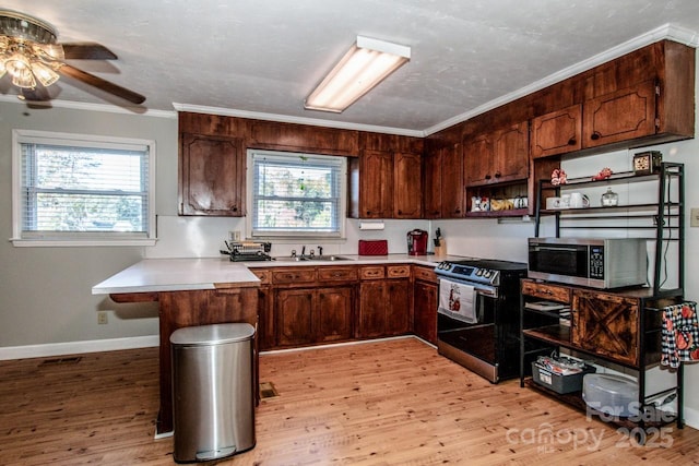 kitchen featuring kitchen peninsula, stainless steel appliances, ceiling fan, and ornamental molding