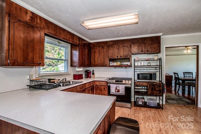 kitchen featuring sink, stainless steel appliances, kitchen peninsula, crown molding, and light wood-type flooring