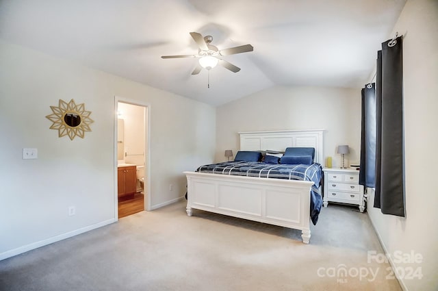 bedroom with ensuite bath, lofted ceiling, light carpet, and ceiling fan