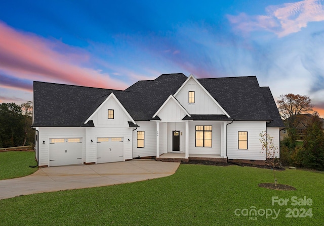 modern farmhouse with a yard and a garage