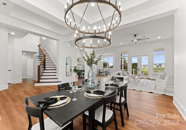 dining room featuring hardwood / wood-style floors, a raised ceiling, french doors, and ceiling fan