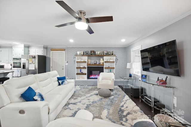 living room featuring dark hardwood / wood-style floors, ceiling fan, crown molding, and brick wall