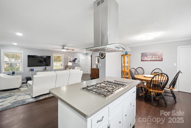 kitchen featuring island range hood, ceiling fan, a center island, white cabinetry, and stainless steel gas stovetop