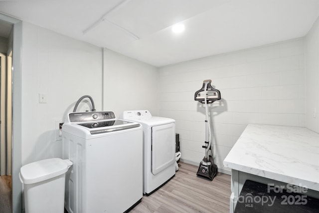 laundry room featuring washer and dryer and light hardwood / wood-style floors