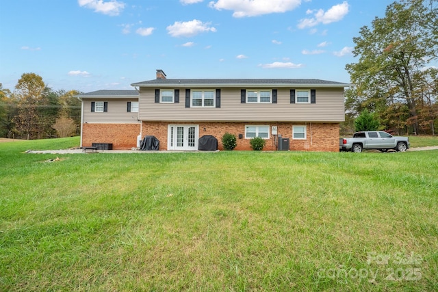 view of front of home with french doors, a front lawn, and central AC unit