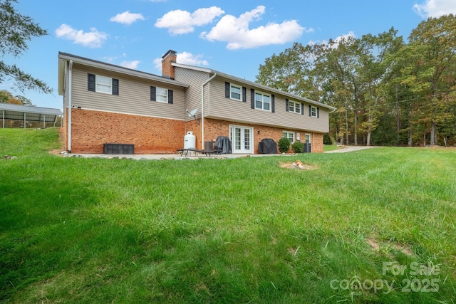 back of property featuring french doors and a lawn